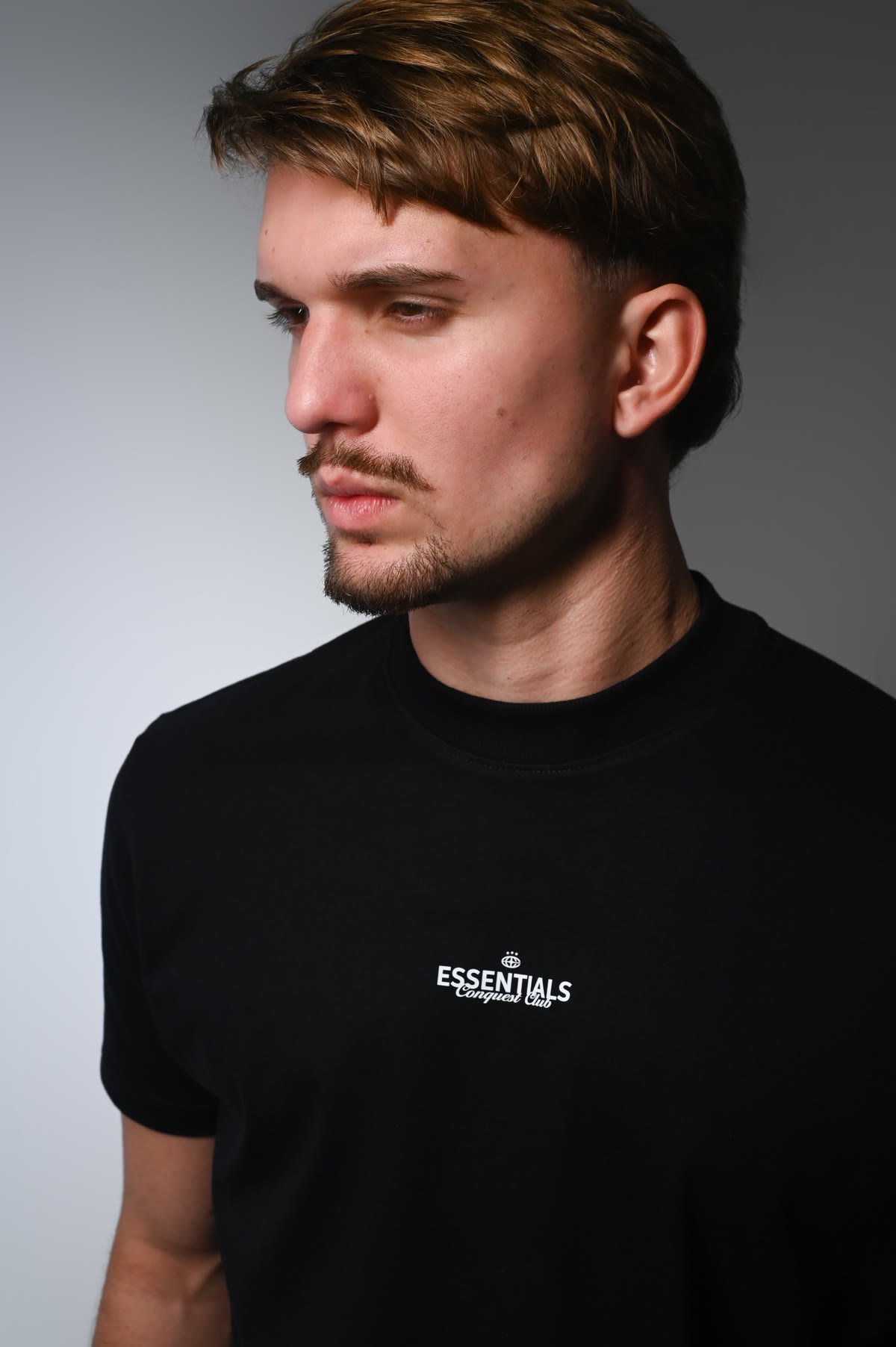Perfil do modelo com camiseta preta Essentials